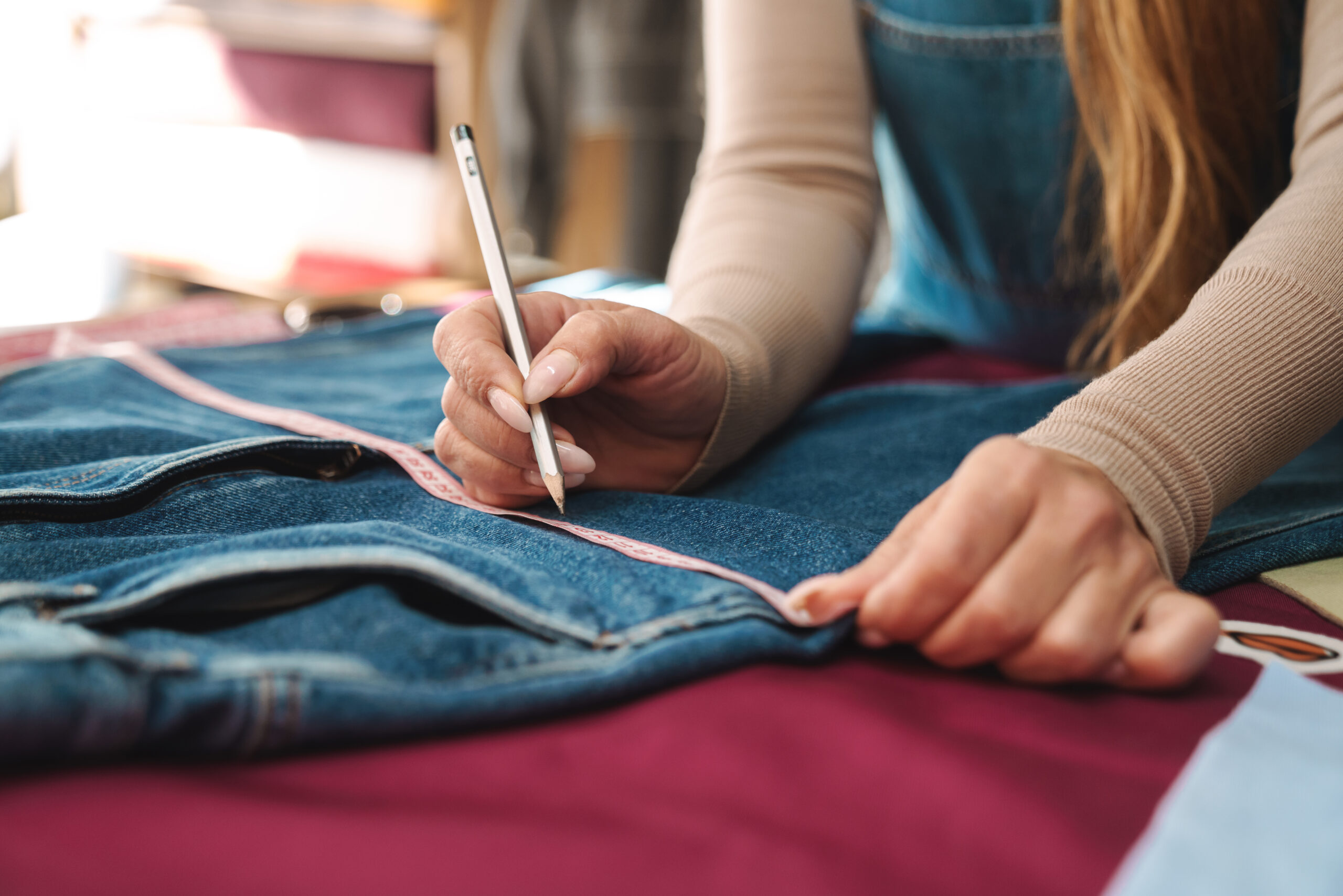 Seamstress measuring jeans for alterations